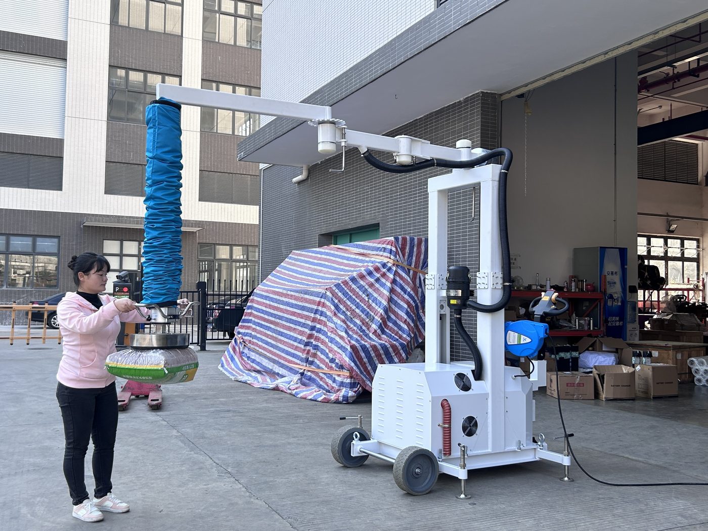 Mobile vacuum tube lifter loading a truck