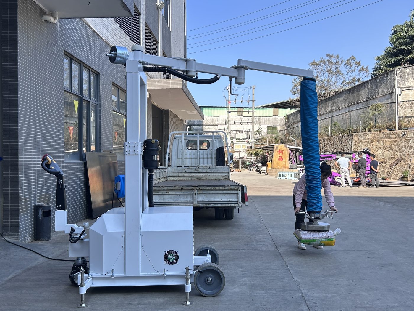 Mobile vacuum tube lifter unloading sacks in the factory yard